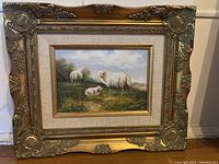 Frontal image showing the full framed oil painting of sheep with clear view of the ornate gold frame and linen mat surrounding the artwork.