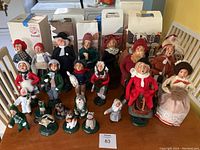 Full lot view showing 24 assorted figures in holiday and other costumes with original boxes behind