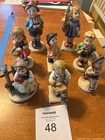 Overview of all 8 figurines displayed on table, showing variety and arrangement.