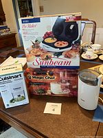 Full lot with three appliance boxes and one loose appliance on tabletop