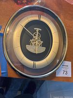 Full view of oval Seiko wall clock with Roman numeral markers and visible internal gears under glass face.