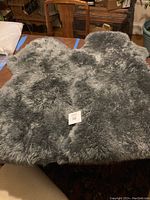 Two silver grey genuine New Zealand sheepskin rugs with plush wool showing natural texture and curls.