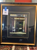 Full front view of framed serigraph showing black mat and gold-tone frame