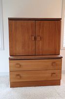 Front view showing two doors and two drawers with wooden handles