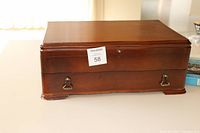 Closed wooden canteen front view showing brass hardware and latch