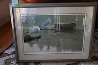 Front view of framed print showing two seagulls on driftwood and water reflection