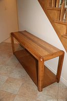 Angle view of the console table showing rounded edges and wood grain.