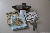 Photo showing all items including Hoselton sculpture, Maxwell pottery canoe, mats, towels, and wooden spreaders arranged together.