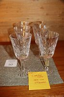 Six Waterford crystal white wine glasses displayed on a mat, showcasing the cut crystal pattern and overall design.