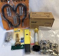 Full lot showing bike locks, light bulbs, hose nozzle, electrical tester, clamps, and spring clamp together.