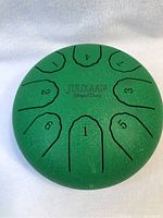 Top view of green Juukaan steel tongue drum showing 8 tongues numbered from 1 to 8.