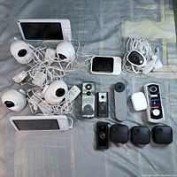 Overview of 3 baby monitor sets and 7 video doorbell units arranged on surface