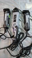 Three power tools laid out with cords visible showing front angled view.