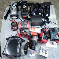 Full lot overview showing all automotive devices including air pumps, chargers, dash cams, and OBD tools.