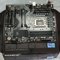 Top-down view of the motherboard on the original box showing chipset heatsink, PCIe slots, RAM slots, CPU socket, and branding.