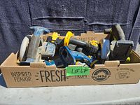 Box of assorted battery-operated power tools including drill, jigsaw and sander showing condition and overall contents.