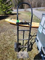 Front view of the black metal convertible hand truck showing 2 position handle and flat base plate with signs of wear.