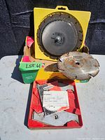 Photo of multiple saw blades including brand Craftsman blades and a partly rusted blade, some mounted on plastic holders and placed on a table surface under sunlight.