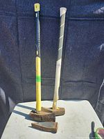 2 firewood mauls with fiberglass handles and heavy splitting wedge arranged vertically, showing full length and condition