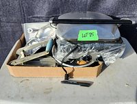 Full view of the lot including panini press, pie plates, French fry cutter, and other kitchen tools in a cardboard box