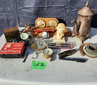 Full lot showing all items on table including barometer, pens, figurine, gauges, coffee pot and horseshoe