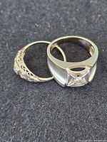 Two rings side by side on black background, top view