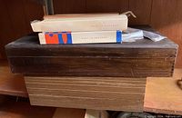 Photo of two wooden storage boxes stacked with cardboard boxes on top.