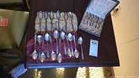 Overview of three spoon sets on table including tan holder, red holder and storage box