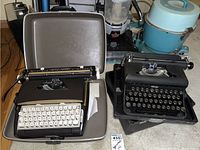 Both typewriters shown together, Royal manual typewriter on right, Sears electric typewriter on left in gray case.