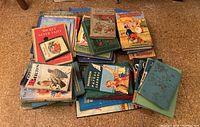 Photo of vintage children's books piled showing various illustrated colorful covers