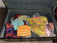 Open vintage trunk containing folded assorted garments