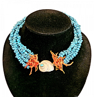Full frontal view of the chunky turquoise necklace displayed on a black jewelry bust, clearly showing the five strands, coral clusters, and shell pendant.