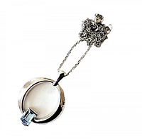 Full view of the pendant and necklace chain showing the circular pendant with a rectangular blue topaz gemstone at the bottom.