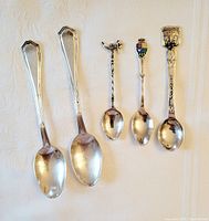 All five sterling silver spoons arranged side by side showing designs and sizes.