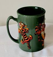 Side angle showing Tigger illustrations in raised relief on large green ceramic mug