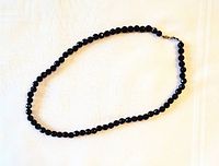 Full view of faceted purple amethyst bead necklace laid out flat showing length and bead detail.