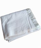 Folded cream-colored wool blanket showing satin trim edge, highlighting condition and material texture.