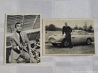 Two black and white trading cards of 1965 James Bond starring Sean Connery. One with Connery holding a gun, the other with Connery posed beside a classic Aston Martin car.