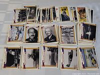 Multiple stacks of WWII trading cards laid out showing generals, propaganda, and various war images.