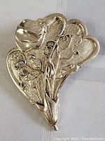 Front view of the vintage silver brooch pin showing detailed floral design and texture.