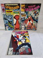 Three vintage Marvel Spider-Man comics laid out showing colorful covers and overall condition.