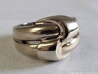 Close-up front angle of the sterling silver abstract ring showing the smooth, polished surface and looped design.