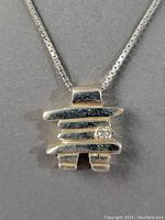 Close-up image of the Inukshuk sterling silver pendant with the inset diamond.