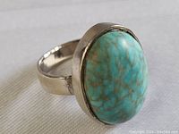 Close-up of the sterling silver ring showing the oval turquoise stone with brown veining and polished silver band.