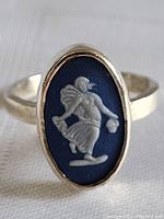 Front view of the sterling silver ring with the oval Wedgwood Jasperware tile featuring a white dancer relief on blue background.