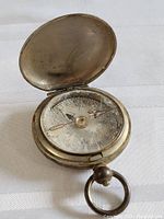 Photo of WWI Terrasse WC compass showing open lid, metal casing, and compass dial with degree markings