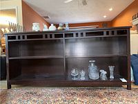 Front view showing full width of the dark wood bookcase with two open shelves and decorative cutouts along the upper section.