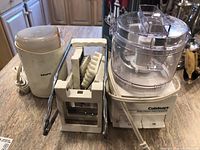 View of Krups coffee grinder next to Cuisinart Mini Prep Processor and white utensil holder with kitchen tools inside, displayed on a countertop
