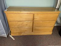 Front view of a wood finish dresser with six drawers, showing the drawer arrangement and condition.