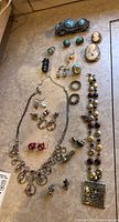 Full layout of lot including brooches, rings, earrings, necklaces, barrette